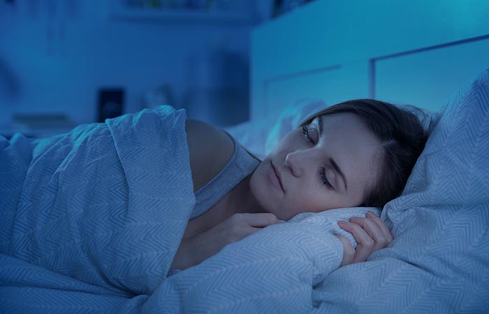 Woman peacefully sleeping in bed at night.