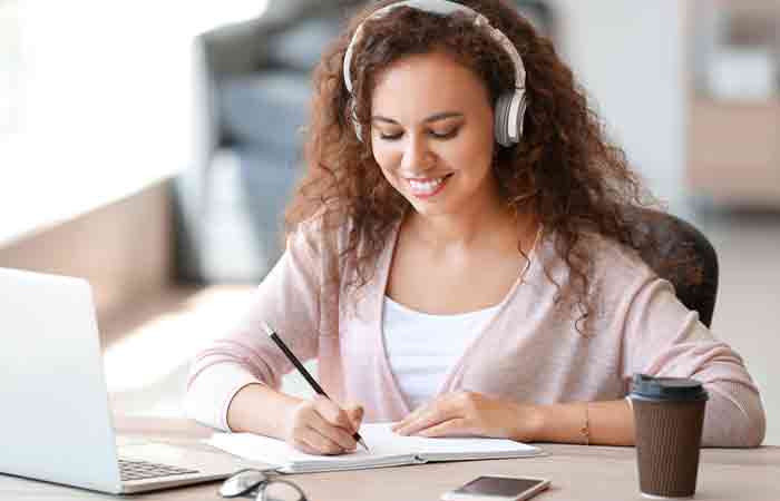 Woman listening to music and studying