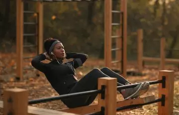 Woman performing crunches in a park at dusk