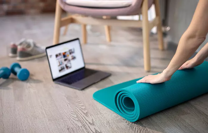 Woman with yoga mat and dumbells