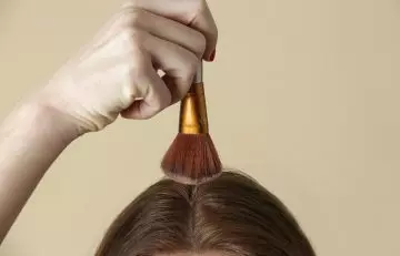 A woman applying hair texture powder