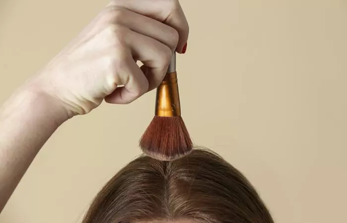 A woman applying hair texture powder