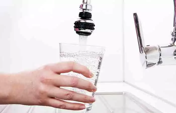 Hand with a glass of filtered tap water