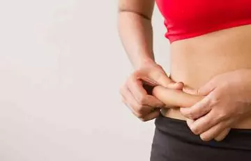Woman pinching the fat on her stomach