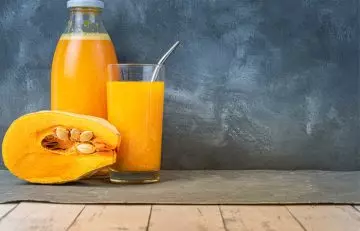 A glass and bottle of pumpkin juice