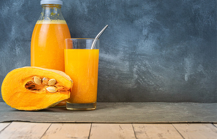 A glass and bottle of pumpkin juice