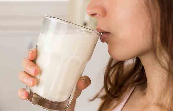 Close up shot of woman drinking glass full of milk.