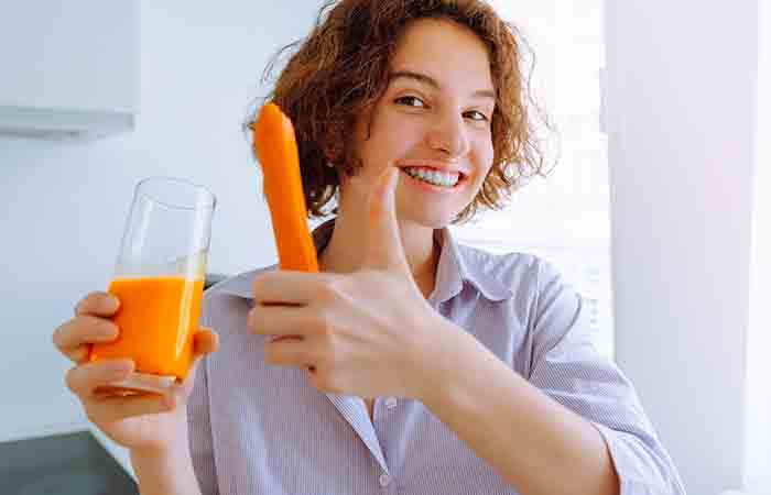 Woman drinking fresh carrot juice for healthy skin