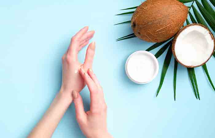 Woman applying coconut oil on her hands to keep them soft