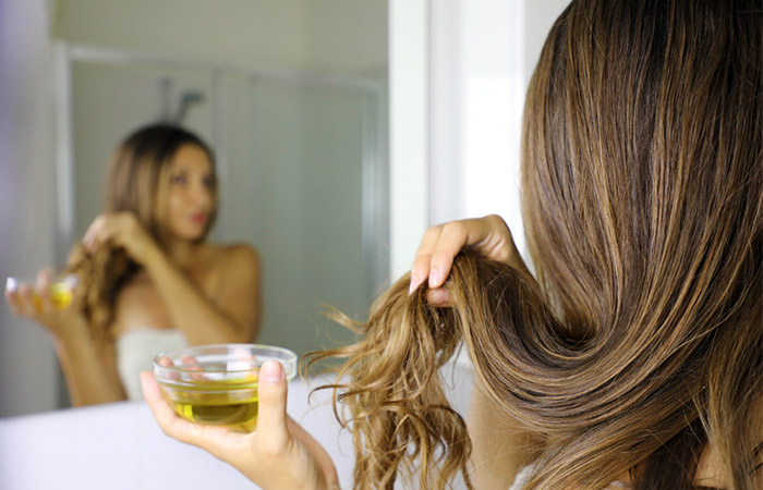 Woman applying a mixture of castor and coconut oils