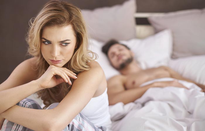 Unhappy woman in bed with her partner
