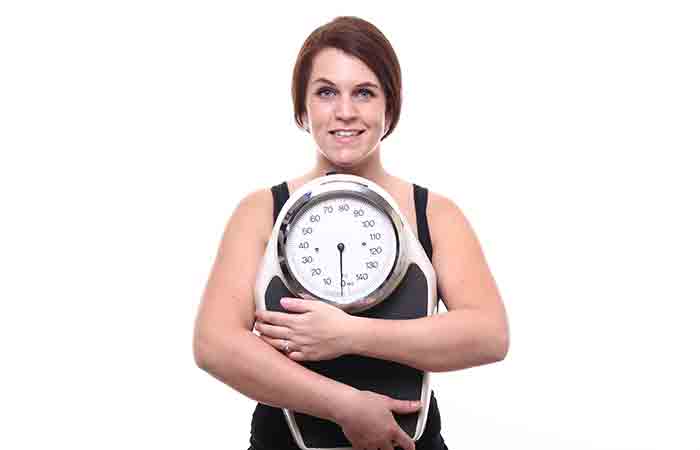Woman with a weighing scale happy that is managing her weight