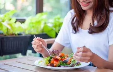 Woman consuming healthy foods to reduce tingling in hands and feet
