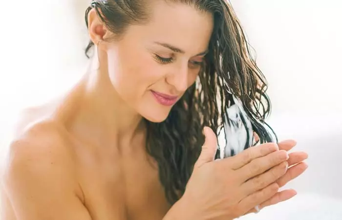 Woman applying conditioner to her hair