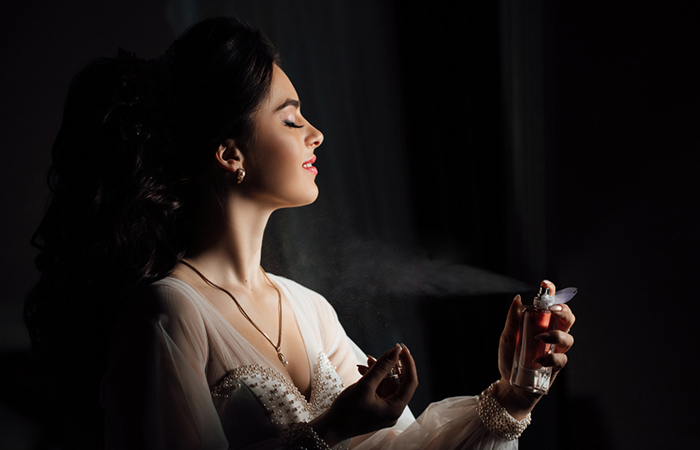 Woman spraying perfume to enhance mood