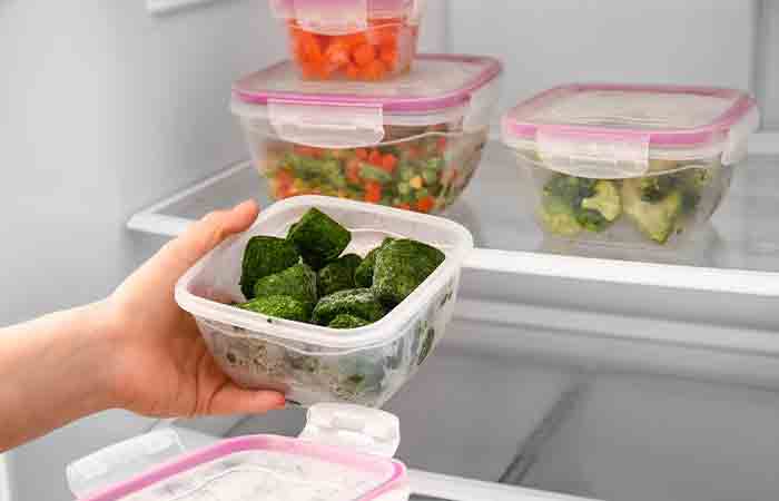 Woman placing a container of food in the fridge