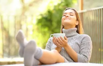 Woman sips rosemary tea and feels stress-free