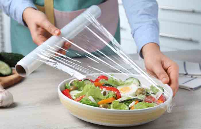 Woman wrapping food in cling film made with LDPE