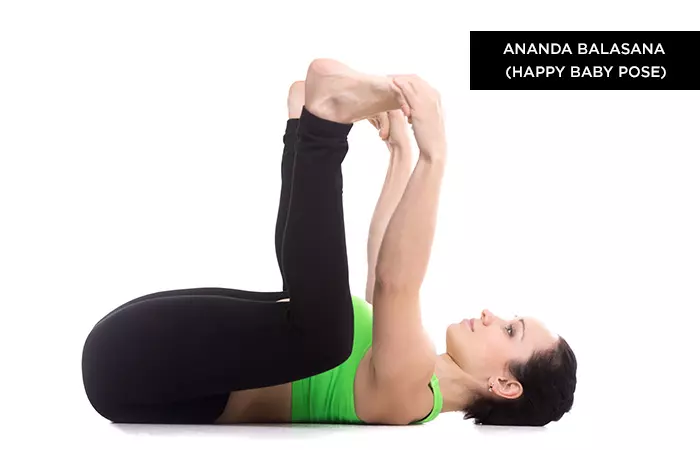 Woman practicing the Ananda Balasana pose