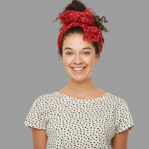 Curly hair gathered in a bun and decked with a red scarf