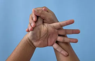 A person massaging the thumb