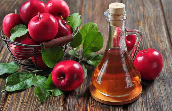 Apple cider vinegar in glass bottle and basket with fresh apples