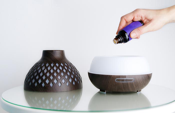 Hand putting essential oil into a diffuser