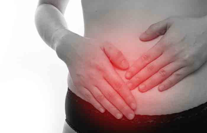 Woman holding her stomach to show digestive issyes