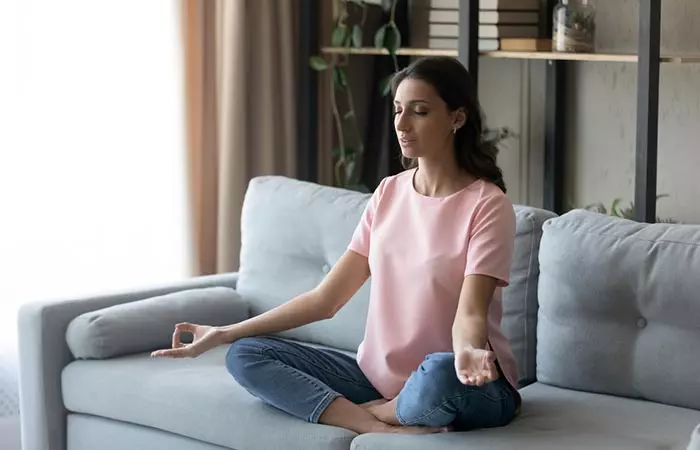 Woman doing breathing exercise at home