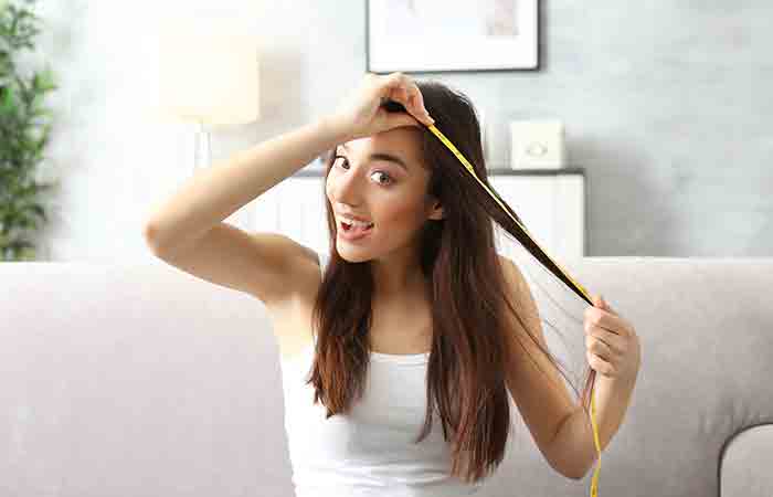 Woman measuring hair length at home