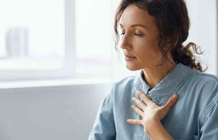 Woman taking a deep breath with eyes closed