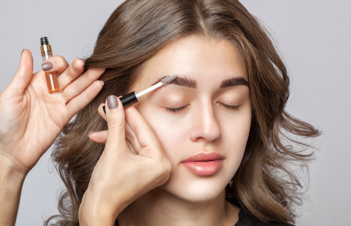 Making natural and fluffy baby-like eyebrows with mascara on woman