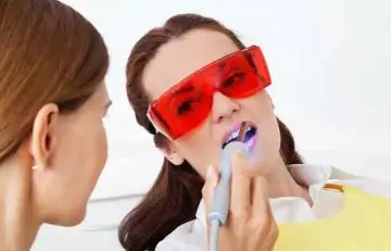 Doctor performing laser therapy on a patient as a treatment for mucoceles