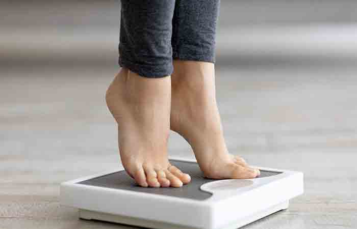 Woman checking weight on the scales