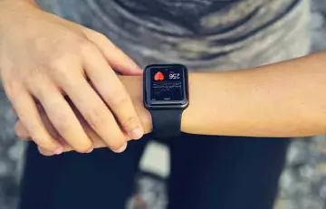 Woman checking pulse rate in smartwatch