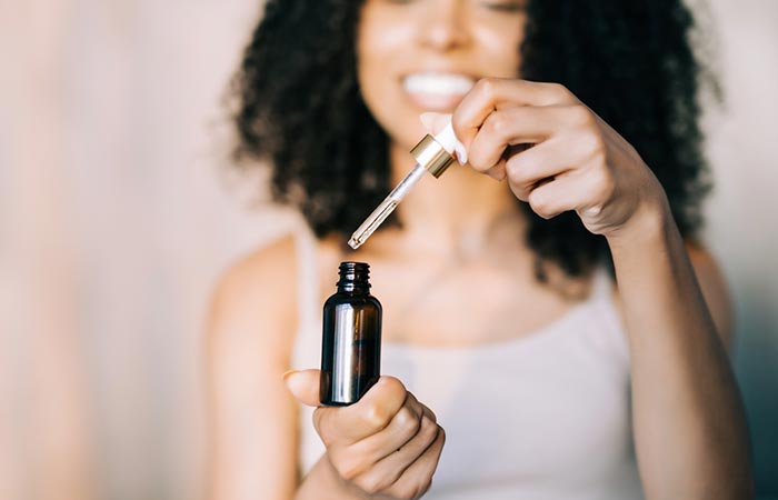 Woman uses vitamin E oil for acne.