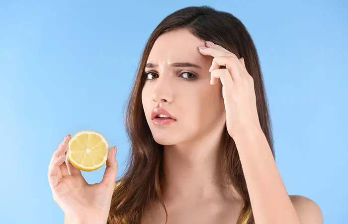 A woman putting lemon on her skin