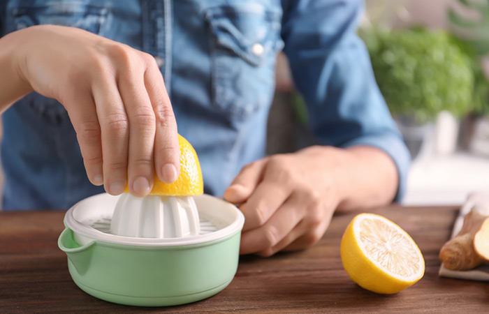 Woman squeezing lemon juice to get rid of underarm odor
