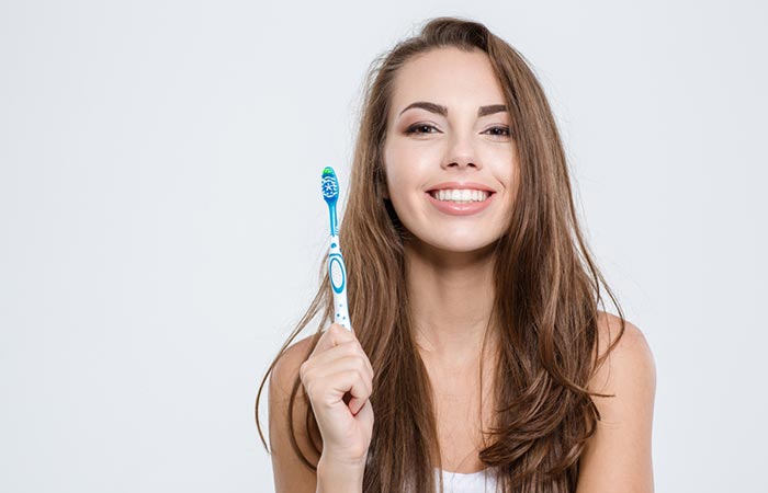 Woman using toothbrush to tame baby hair