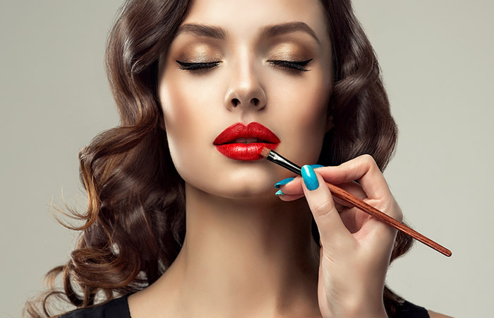 Woman applying red lipstick 