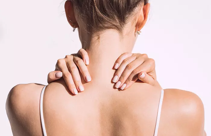 Woman massaging her neck to get rid of hickey