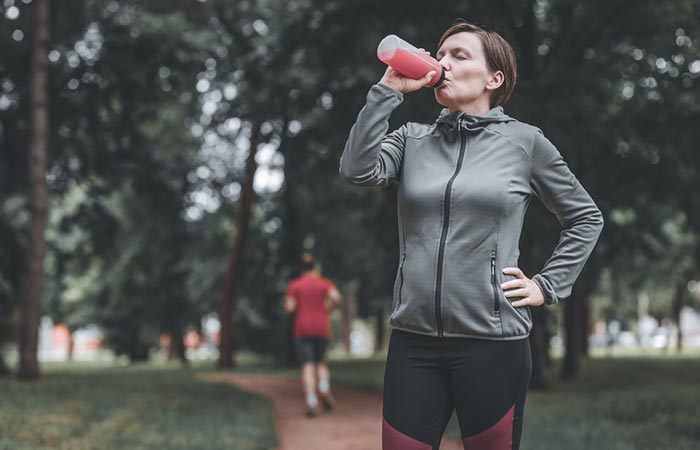 Female jogger drinking healthy prune juice
