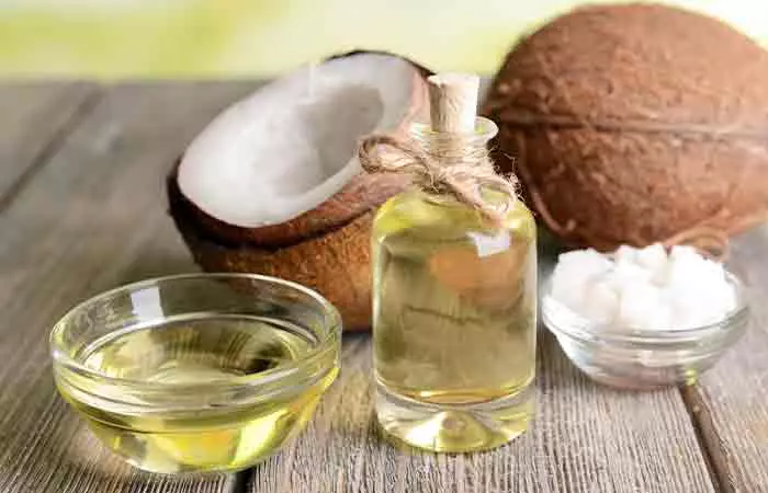 Coconut oil in a glass bowl and glass bottle