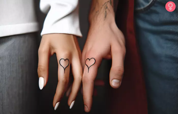 A couple with matching heart tattoos on their index finger