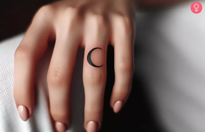 A crescent moon black silhouette on the ring finger