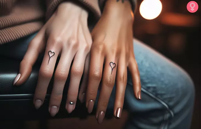 A mother and daughter tattoo of matching finger heart tattoos
