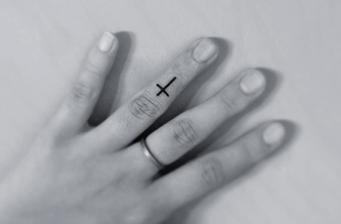 The cross tiny finger tattoo
