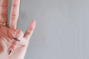 Tiny word finger tattoo