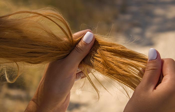 Woman showing dry an brittle golden hair