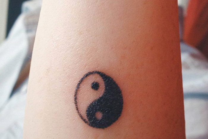 Yin-yang tiny tattoo on wrist